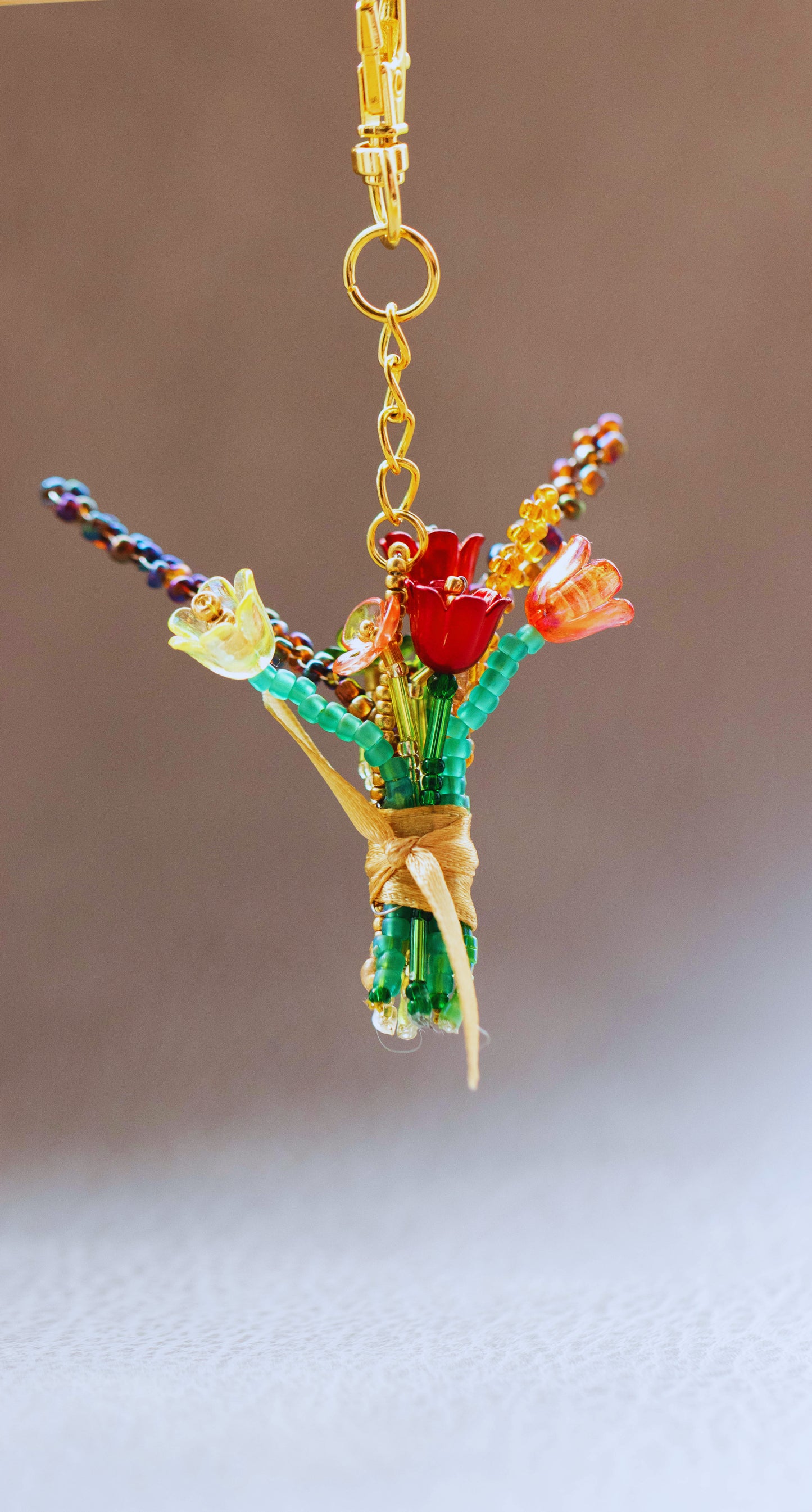 Colorful beaded bouquet keychain on a plain background