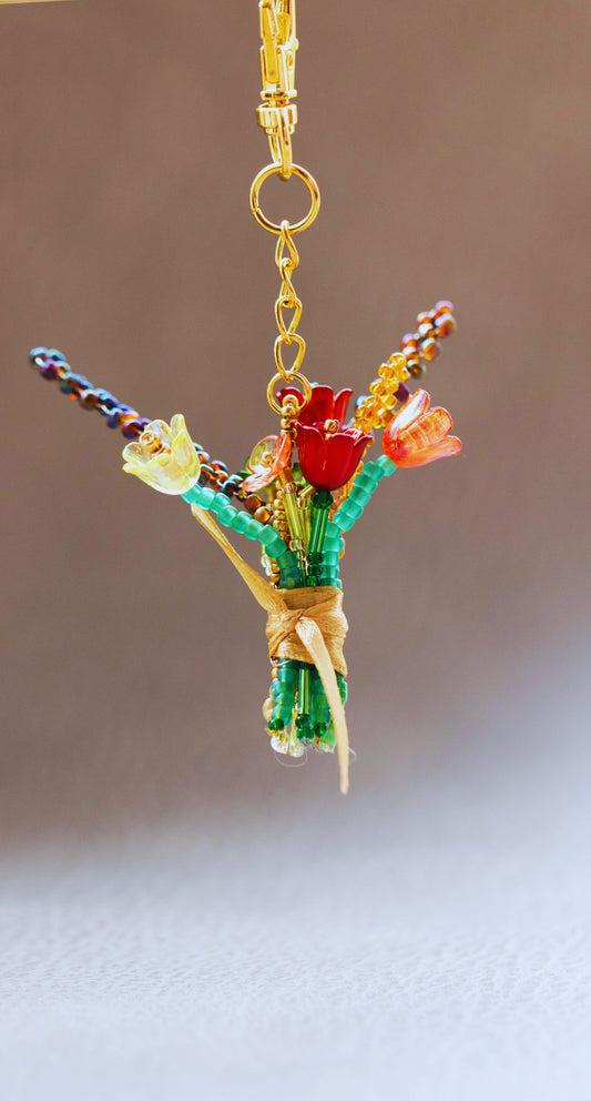 Colorful beaded bouquet keychain on a plain background