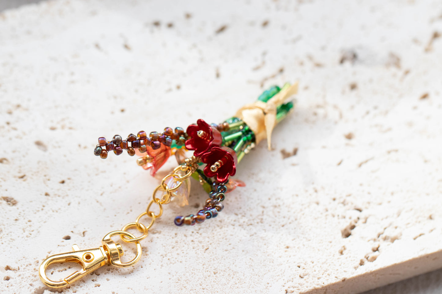 Colorful beaded keychain with flowers on a textured surface