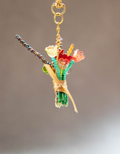 Colorful beaded bouquet keychain on a plain background