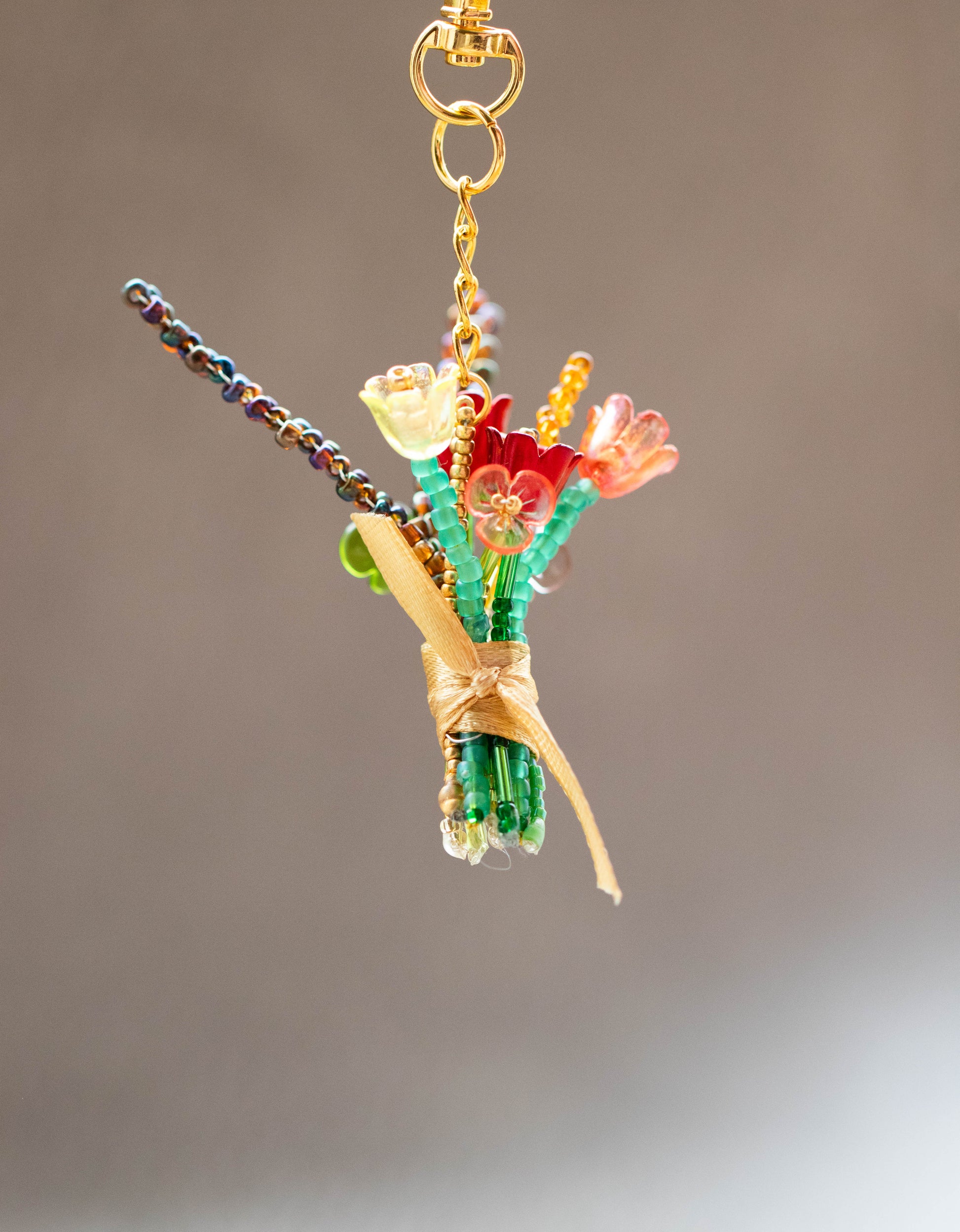 Colorful beaded bouquet keychain on a plain background