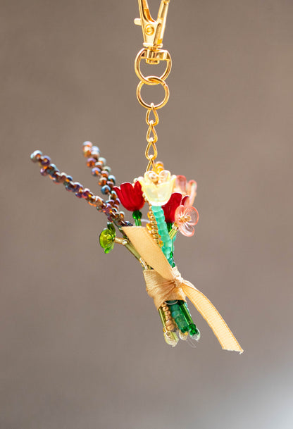 Decorative keychain with flowers and beads on a plain background