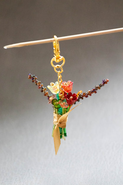 Colorful beaded bouquet charm on a stick against a neutral background