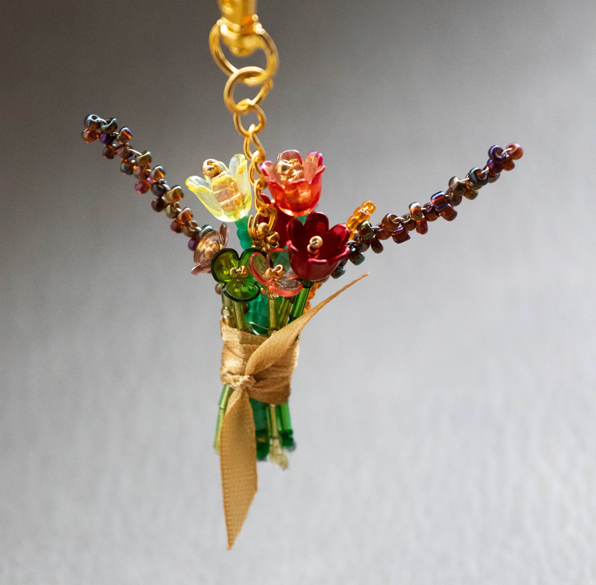Colorful glass flower bouquet keychain on a gray background