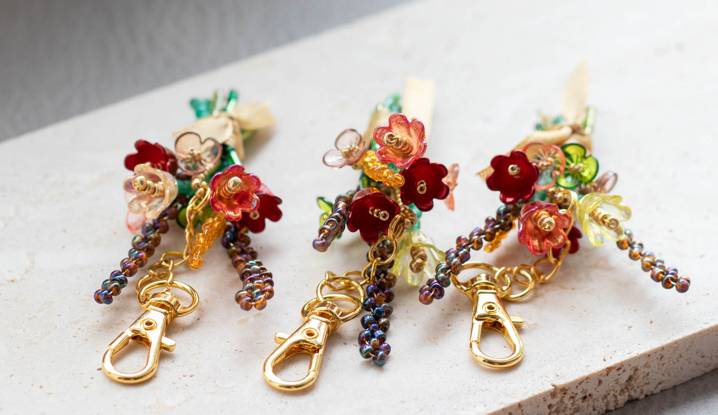 Colorful beaded keychains with floral designs on a light surface
