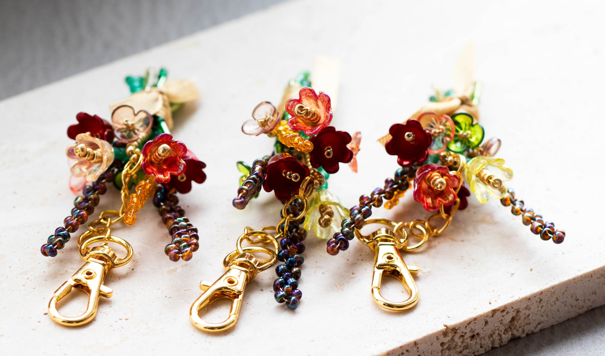 Colorful beaded floral keychains on a light surface