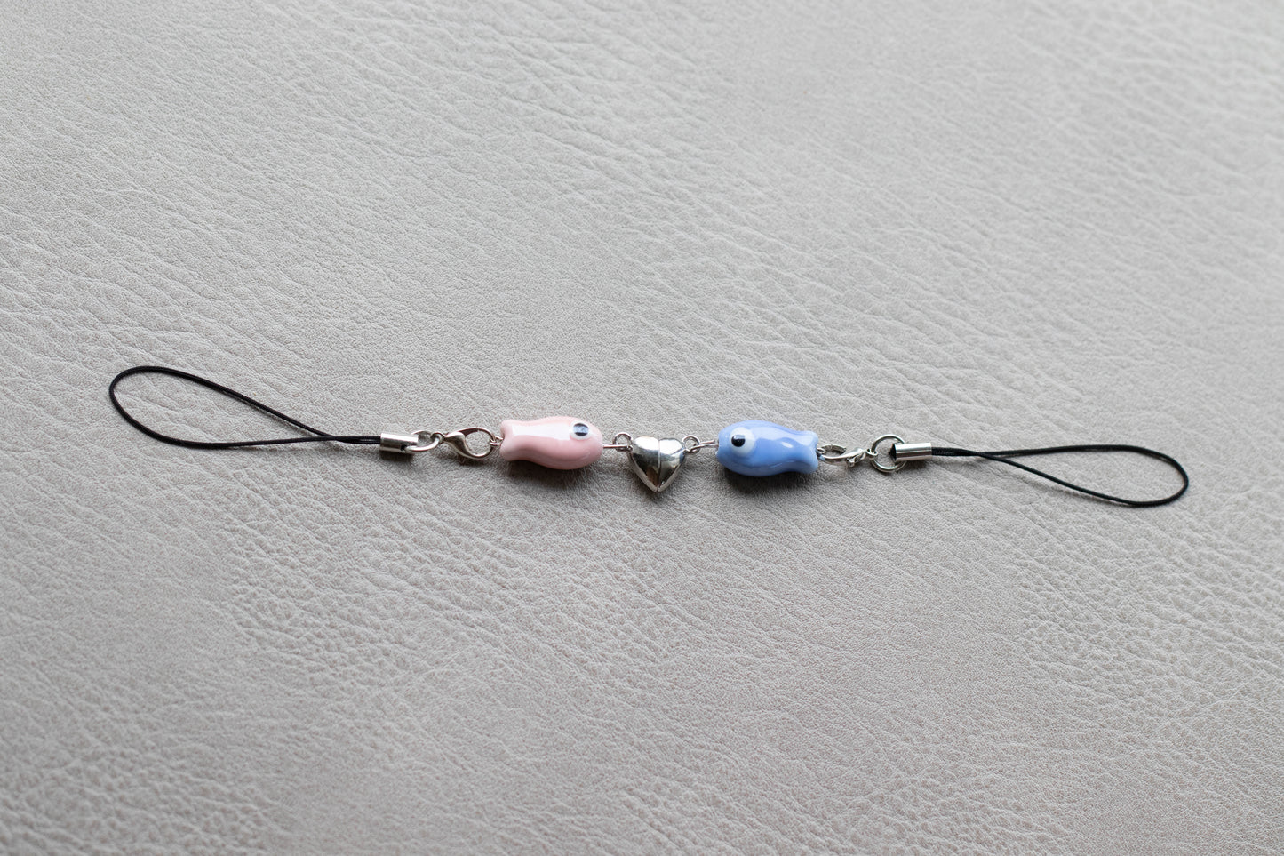 Phone charm with beads on a gray surface