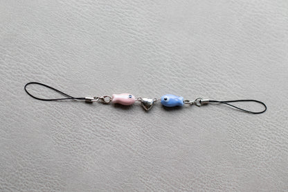 Phone charm with beads on a gray surface