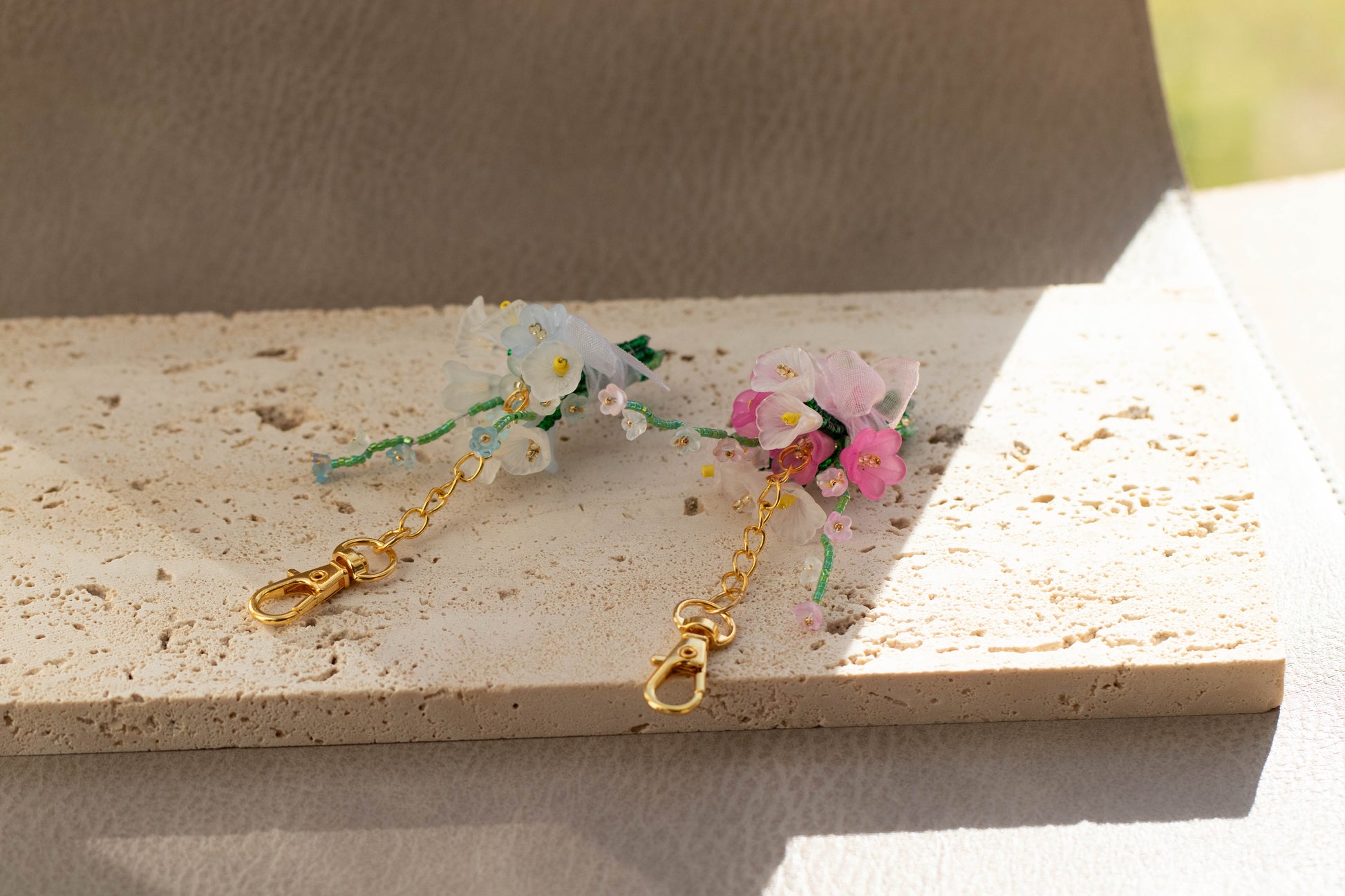 Floral keychain with gold chain on a textured surface