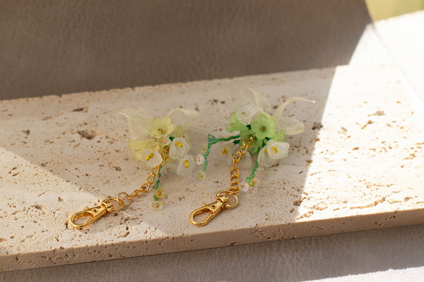 Floral keychain with gold clasp on a textured surface