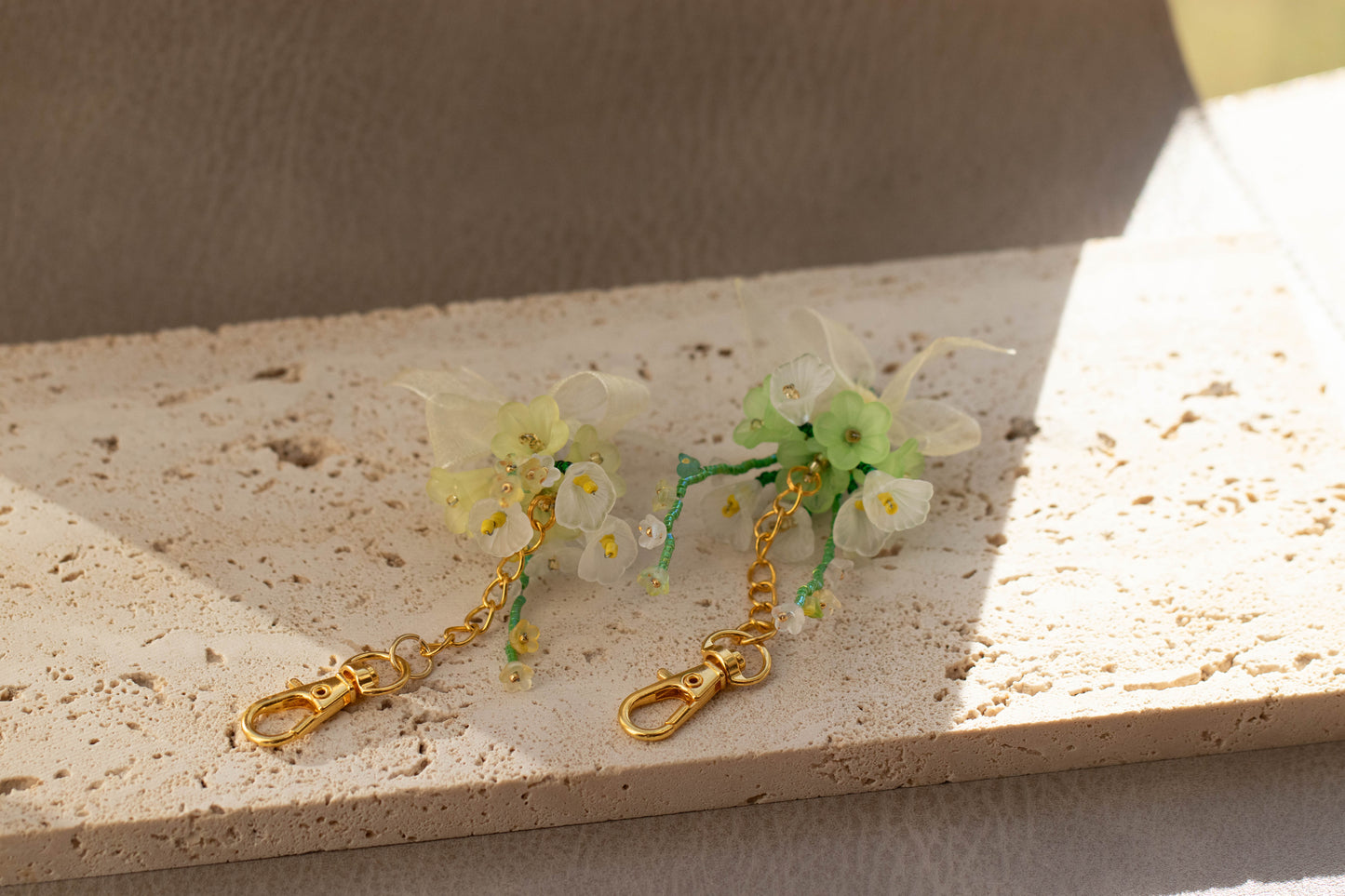 Floral keychain with gold chain on a textured surface