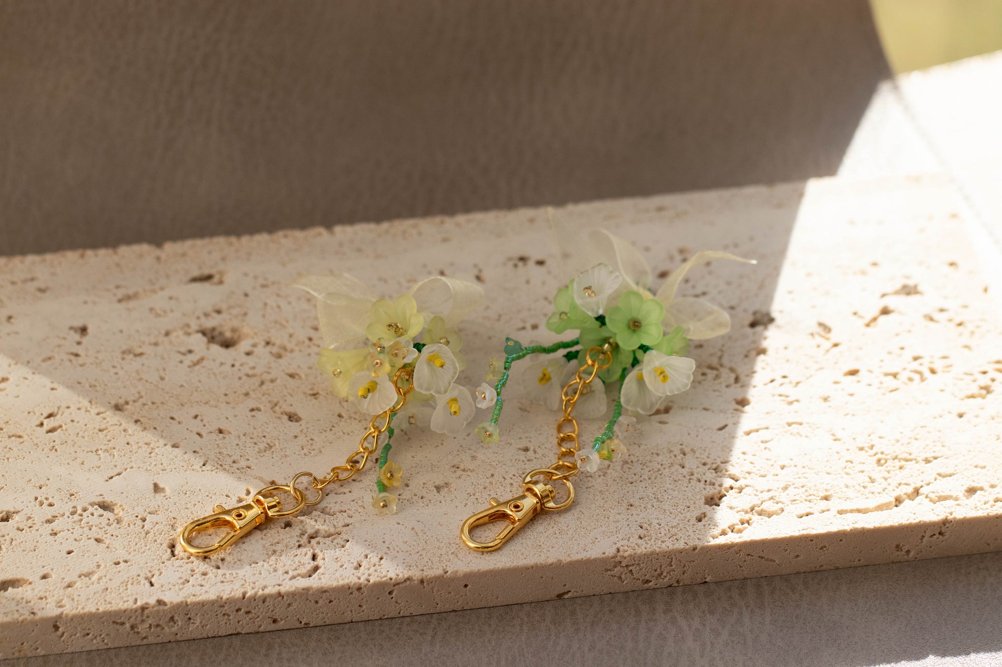 Floral keychain with gold chain on a textured surface