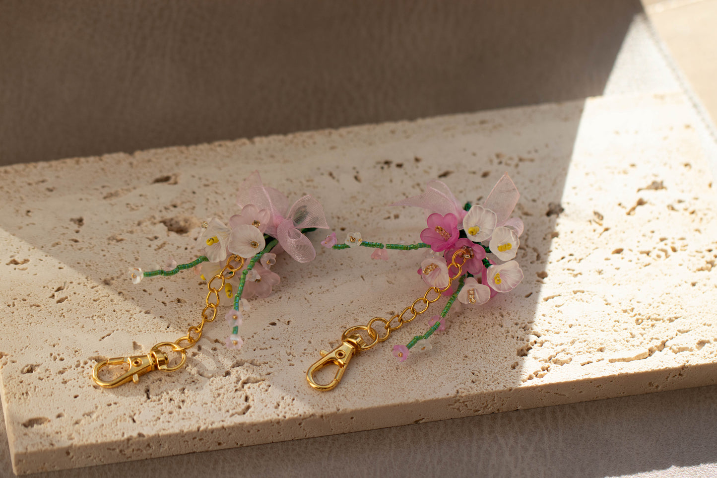 Floral keychain with gold chain on a textured surface