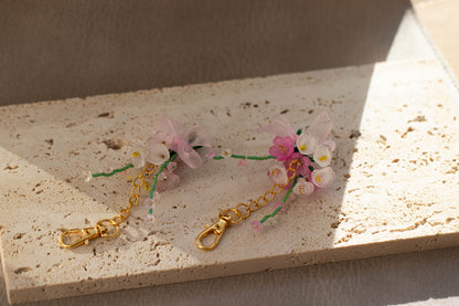 Floral keychain with gold chain on a textured surface